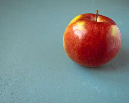 Ripe red and yellow apple fruit on blue wooden backgroundの写真素材
