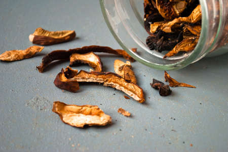 Dried mushrooms in glass jar on gray table. Close upの写真素材