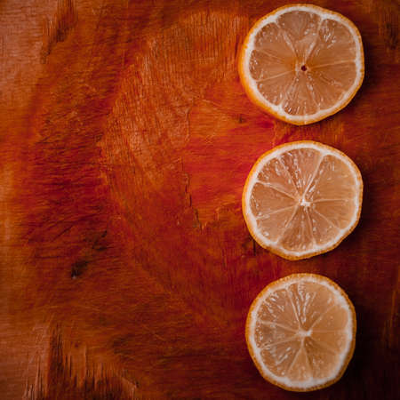Round slices of ripe lemon on rustic wooden backgroundの写真素材