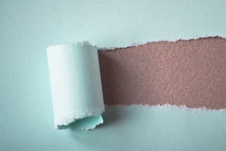 Light blue torn paper in the center opening and showing brown cardboard background