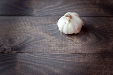 Whole head of fresh garlic on brown wooden tableの写真素材