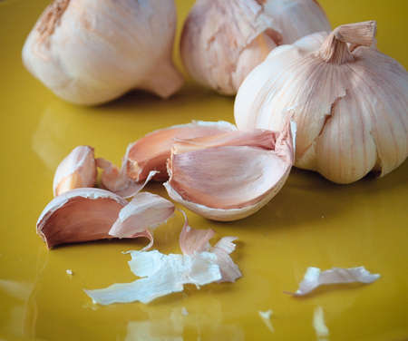 Fresh raw garlic on yellow plate. Close upの写真素材