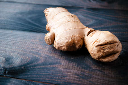 Whole root of fresh ginger on rustic wooden backgroundの写真素材