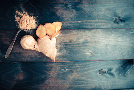 Fresh ginger root and spoon with dry ginger on shabby rustic backgroundの写真素材