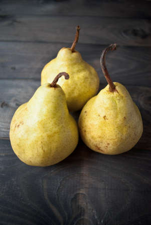 Three fresh ripe yellow pears on wooden backgroundの写真素材