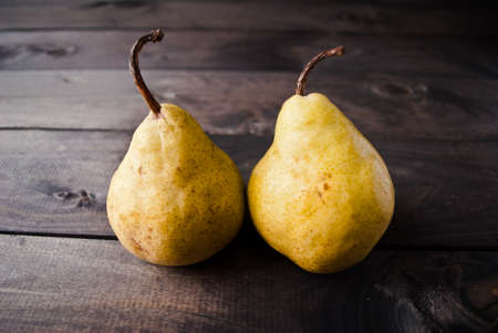 Fresh juicy yellow pears on brown wooden backgroundの写真素材