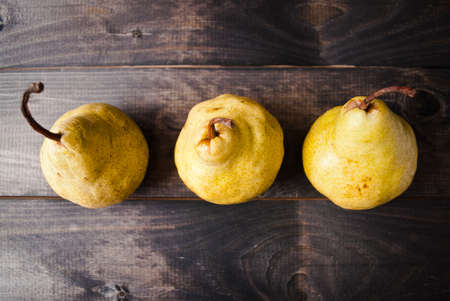 Ripe yellow pears in a row on rustic background. Top viewの写真素材