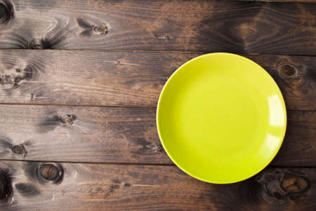 Top view of empty plate on rustic wooden background. Copy spaceの写真素材