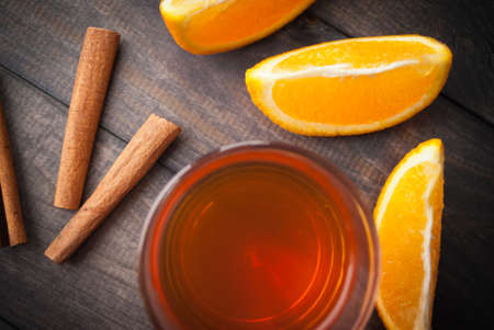 Cup of black tea, cinnamon sticks and oranges. Top viewの写真素材