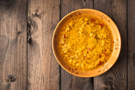 Red lentil soup in brown bowl on rustic wooden backgroundの写真素材