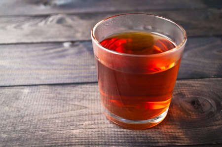 Glass of black tea on wooden rustic backgroundの写真素材