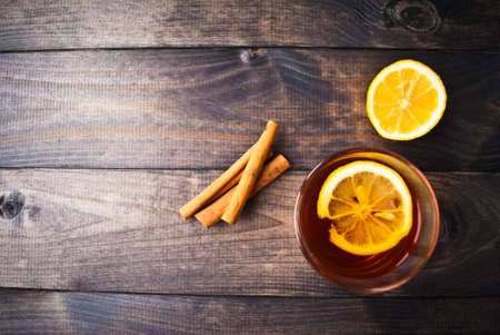 Cup of black tea with lemon slice, half of lemon and cinnamon sticks. Top viewの写真素材