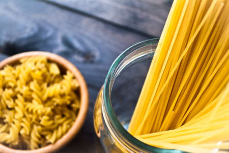 Two kind of raw pasta on blue rustic wooden surfaceの写真素材