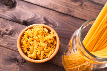 Two kind of raw uncooked pasta on wooden background. Copy spaceの写真素材