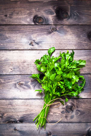 Tied bunch of fresh parsley on wooden background. Space for textの写真素材