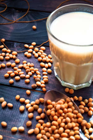 Glass of soy milk and soy beans on blue wooden backgroundの写真素材
