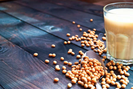 Glass of soy milk and soy beans on wooden background. Copy spaceの写真素材