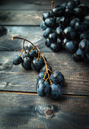 Bunch of black grapes on a wooden backgroundの写真素材