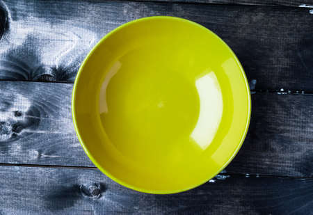 Empty yellow bowl on a blue wooden background. Top viewの写真素材
