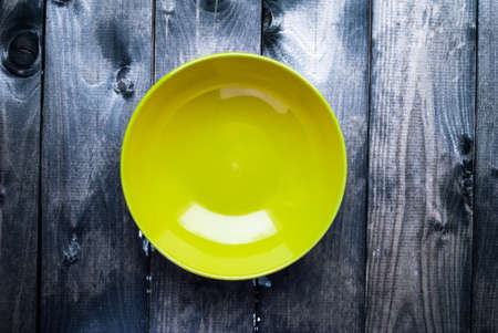 Empty yellow soup plate on a blue wooden backgroundの写真素材