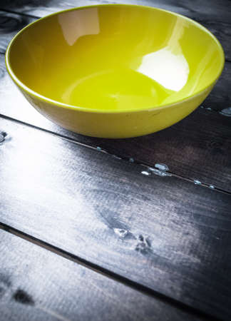 Empty yellow soup plate on a blue wooden backgroundの写真素材