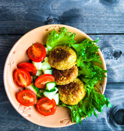 Fried chickpea falafel and some vegetables in ceramic bowlの写真素材