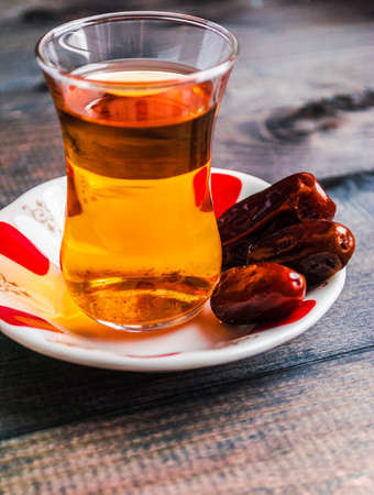 A glass of black tea and dates on a saucer, traditional cuisineの写真素材