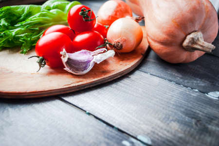 Raw vegetables prepared for cooking on a cutting board. Healthy food background. Space for textの写真素材