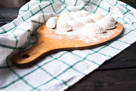 Raw dumplings sprinkled with flour on a cutting boardの写真素材