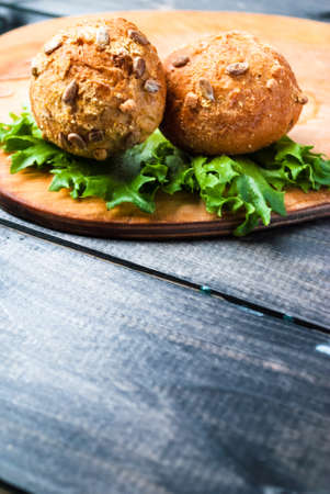 Burger with lettuce on rustic wooden cooking board, copy spaceの写真素材