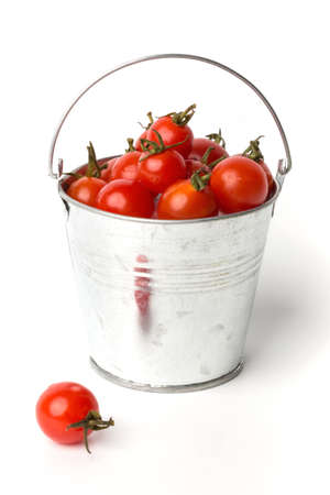 Fresh tomatoes in a pail isolated on white backgroundの写真素材