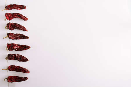 Dried red paprika  on string with white backgroundの写真素材