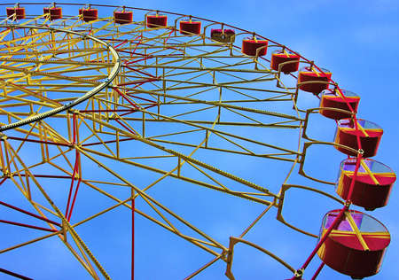 Attraction in an amusement park carousel Ferris wheel on a background of a blue sky
