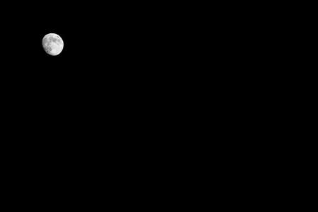 Bright little full white moon on a black sky at night, background, copyspace, spaceの写真素材