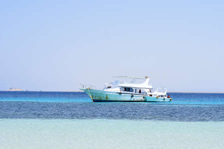 Tourist ship runs in the red sea near a coral reefの写真素材