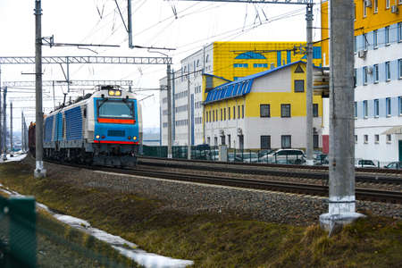 The freight railroad train travels along the railway tracks