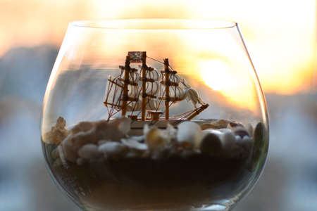 Sea old ship in a bottle and a glass wine glassの写真素材