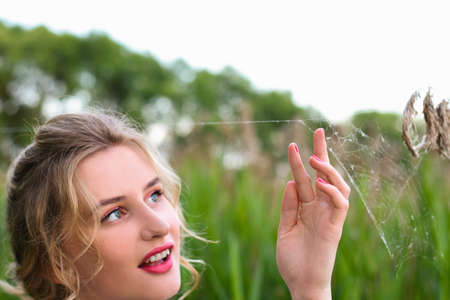 woman hand touching the web of a spiderの写真素材