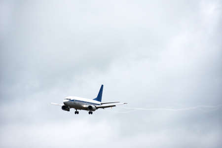 Passenger liner takes off into sky from the airport runway in cloudy weather with rainの写真素材