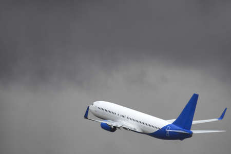 Passenger liner takes off into sky from the airport runway in cloudy weather with rain