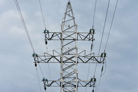 High voltage power tower and electrical lines against sky