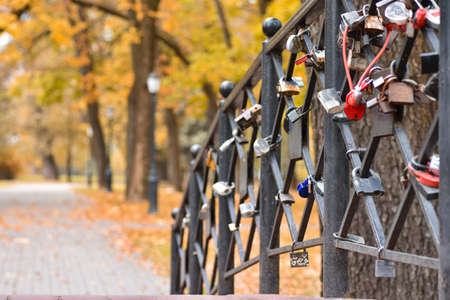 Romantic bridge with locks people in love in autumn parkの写真素材