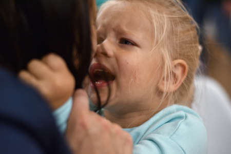 Little girl cries and asks to buy a toy from her mother, portrait, tearsの写真素材