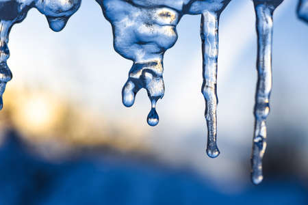 Icicles hang from the roof and melt when weather warmsの写真素材