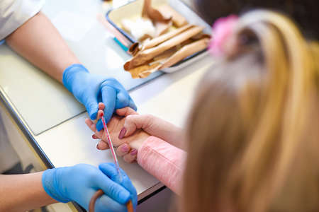 Doctor takes blood tests from the finger of the child with the mother