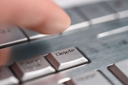 Finger hand presses the Delete button on keyboard, close-upの写真素材