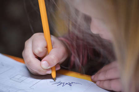 The child learns to write and draws a pen around the contour lineの写真素材