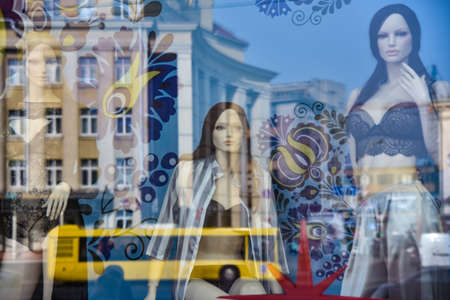 Mannequins in swimsuits on the store's wicker behind glass.の写真素材
