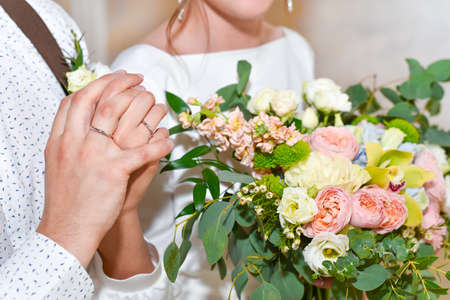 Bride and groom show wedding rings.
