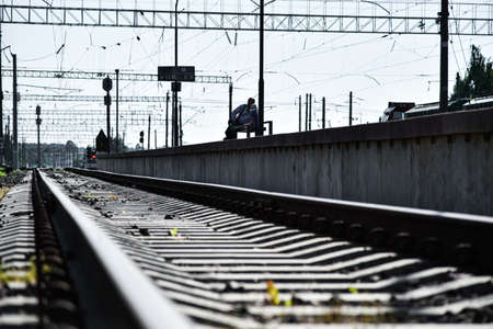 Man and child waiting for the train at the railway station.